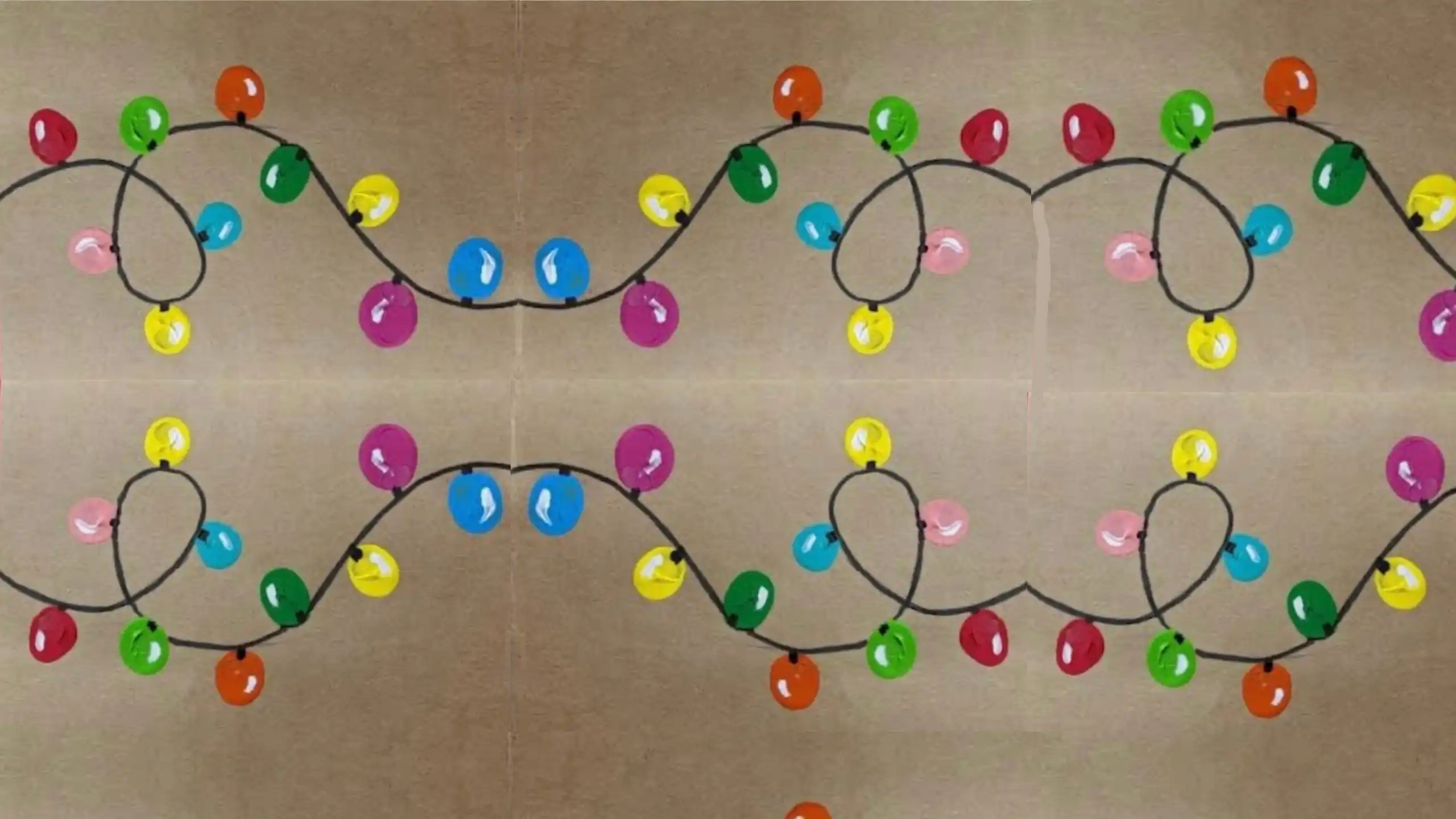 Colourful Christmas lights form a looping pattern on a card, creating a festive, mirrored design.